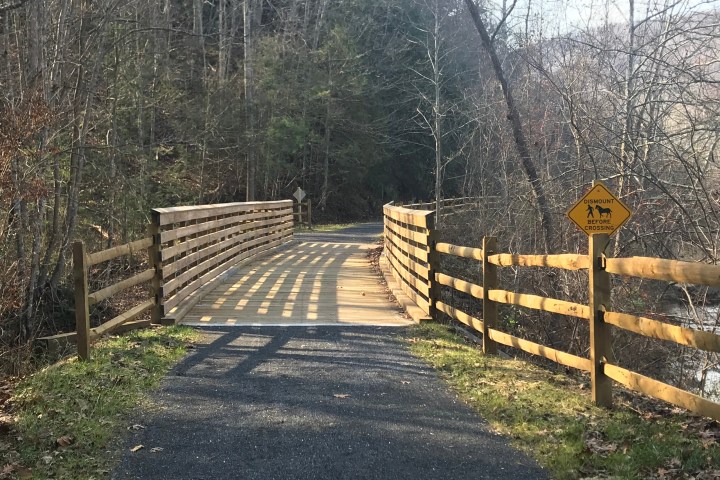 a wooden bench sitting next to a fence