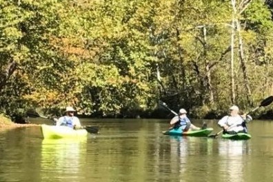 a group of people riding on the back of a boat in the water