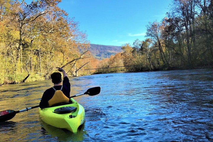 a man riding on the back of a boat in the water