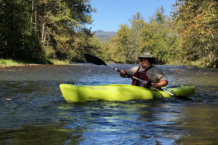 a man riding on the back of a boat in the water