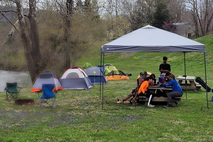 a group of lawn chairs sitting on top of a grass covered field
