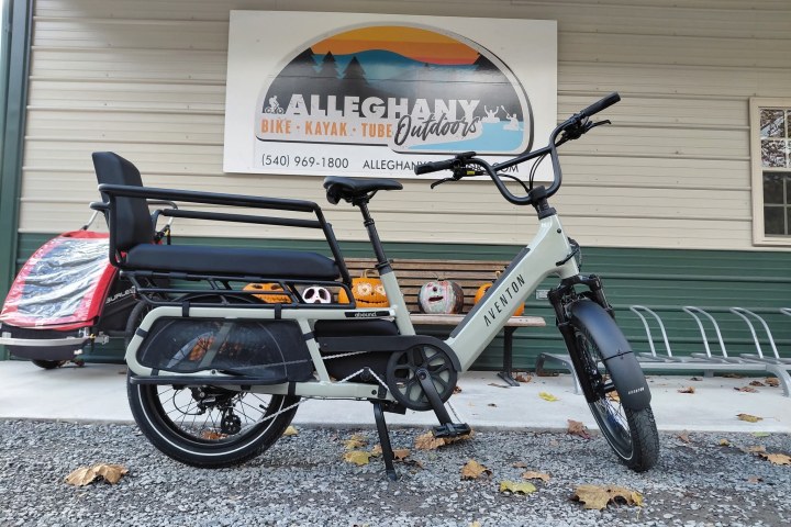 Electric bike with cargo seat parked outside Alleghany Outdoors shop.
